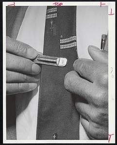 The Clasp with nail mounted on it is memento being given to all Lynn GE non-striking workers who drove their cars to work through carpets of nails laid down by strikers. This clasp is being shown by Gerhard Neuman of Swampscott, general manager of small aircraft engine dept.