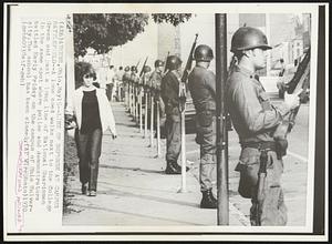 Line of Defense at Campus Battlefield -- A lone coed walks next to the College Green and past a long line of National Guardsmen in the same spot where police and demonstrators battled Early Friday on the campus of Ohio University. The school has been closed.