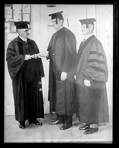 Charles Lindbergh in cap and gown being handed a document, probably an honorary degree