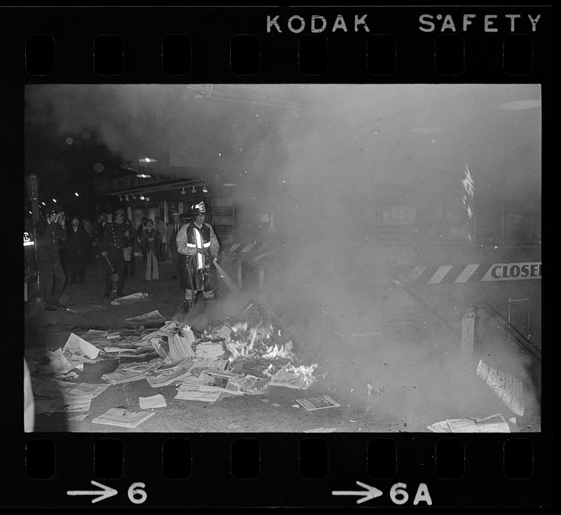 Harvard Square anti-war riot: Burning newspapers at subway kiosk, Cambridge