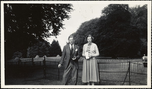 Man and a woman standing in front of a metal fence