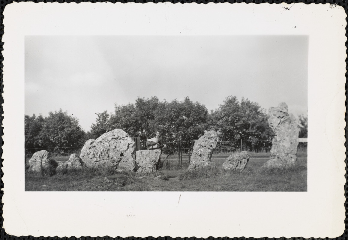 Man standing by a row of pitted standing stones