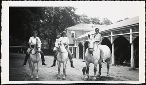Three women sit astride three light-colored bridled horses, bareback