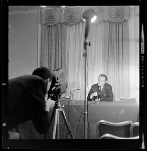 Cameraman capturing Evangelist Billy Graham during news conference at the Statler Hotel