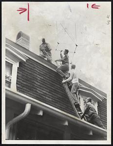 Joseph Paris, 320 Beale St., Quincy, hauls down the TV antenna from the roof of his home. He is being assisted by Francis Rull, Richard Paone and Richard Kelsey.