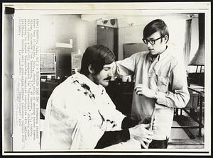 Trimming That Gap - Dartmouth student Peter Fogg of Boulder, Colo., checks skill of amateur barber Steven Shirley, classmate from Rochester, N.Y., at Hanover, N.H., campus. With classes officially suspended for "discussions" students were preparing to invade Vermont-New Hampshire countryside with anti-war petitions. Haircuts were a precaution against long-haired hangups from citizens.