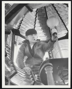 Daily Checks are made of the huge bulbs which shine against reflectors to cast a 110,000- candlepower ray far out to sea. Electrician Ray Benway performs taht duty.