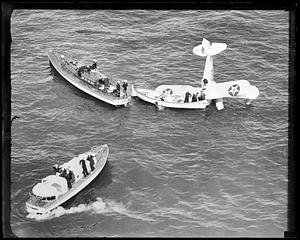 People being rescued by boats from United States Army Air Service airplane wreck