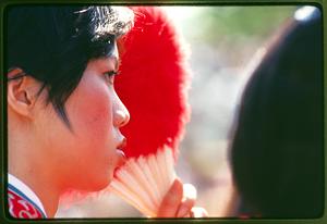 Boston - Hatch Shell: Holding a fan, a woman watches activities at the Dragon Boat Festival - 1981