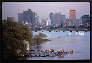 College crews practice on Charles River, Boston University boathouse in foreground, Boston
