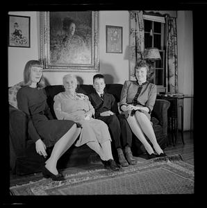 Three women and young boy on sofa