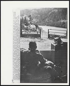 He Watched the River From Inside--A teen age boy of the Studebaker family, invalided and his legs in braces, watches as the rest of his family greet a helicopter bringing relief supplies. This young man sat in the picture window and watched the Eel river (at right) rise to flood stage through field glasses. Army, Navy, Marine and Civilian helicopters are flying at every opportunity with food, clothing and medical supplies where necessary. McCann is 65-70 miles south of Eureka.