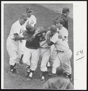 There's Joy in Metsville as the amazin' New York Mets win their first game of the season after eight losses. Rookie Ron Hunt is mobbed by his teammates after his double beat the Braves 5-4 in New York yesterday.