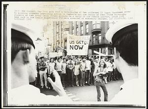 A Wave From a Sailor -- One of two uniformed US Coast Guardsmen waves to marching students protesting action in Cambodia and the deaths of Kent State University students as they cross Canal Street enroute to a rally in the French Quarters. About 1000 took part in the 6-mile march where six were arrested on obscenity charges.