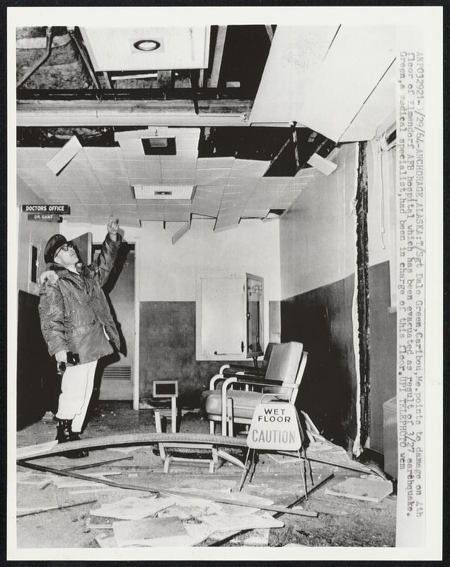 T/Sgt Dale Green, Caribou, Me. points to damage on 4th floor of Elmendorf AFB hospital which has been evacuated as result of 3/27 earthquake. Green, a medical specialist, had been in charge of this floor.