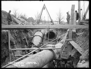 Distribution Department, Low Service Pipe Lines, part of Section 1, trench showing vertical curve and part of pipes under Boston Water Works mains, station 3+26, from the west, Brighton, Mass., Dec. 3, 1897