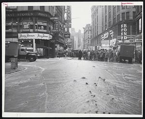 Traffic Was Halted when a water main broke at the corner of Boston's Washington and Boylston Sts. At left, water from the break pours into an MTA subway station and, at right, passersby watch the muddy torrent race toward Kneeland St. It washed up over sidewalks and flooded many cellars.