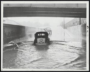 Today's Boston Floods, caused by the new rains, included this one underneath Massachusetts avenue bridge on Embankment road. At times low spots on the new highway had as much as three feet of water on the pavement.
