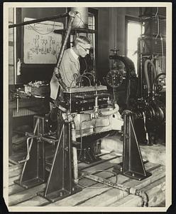 The single sleeve valve four-cycle automobile engine, designed on a new principle, developed in the automotive research laboratory of Massachusetts Institute of Technology in cooperation with its inventor, Luther A. Gaw, of Cincinnati, who is shown running the engine on a water brake test. the outstanding feature of the new engine which is pronounced a notable advance in sleeve valve motors, is the single light steel sleeve valve of steel, which slides between the cylinders wall and the piston, The engine is almost noiseless in operation and has shown fuel and oil economy in road tests of more than 10,000 miles.