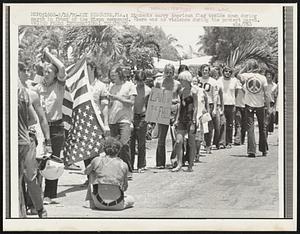 Students carry American flag upside down during march in front of the Nixon compound. There was no violence during the protest march.