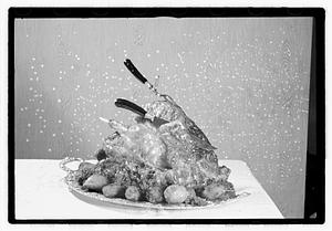 Carving knife and fork in cooked turkey