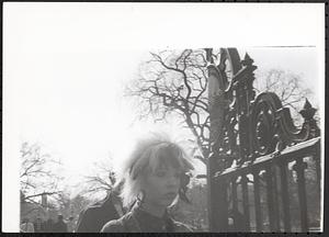 A woman walking past a gate