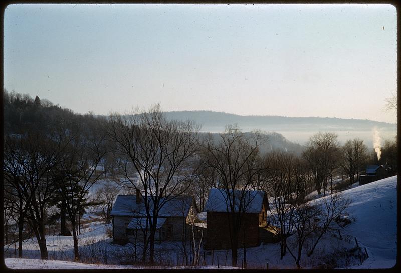 View from snow-covered hill of houses and trees