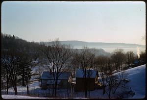View from snow-covered hill of houses and trees
