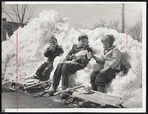 Sun, Snow And No School - Enjoying sun while using snowbank for seats, Richard Greene, 5, Michelle Silowan, 12, and Richard's sister, Karen, 7, have lunch so as not to lose any time from play. They live on Blanchard boulevard Braintree.