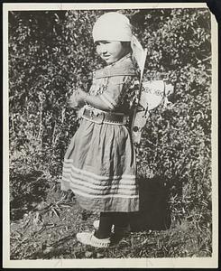 One Hundred Per Cent American! Mothers and mothers the world over - even in Glacier National Park, Montana, where this little Indian girl is doing exactly what her mother does.