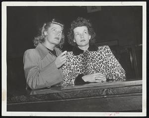 Waiting for Their Braves to arrive at Back Bay Station were Mrs. Charles "Red" Barrett (left) and Mrs. Johnny Sain shown checking the bulletin board.