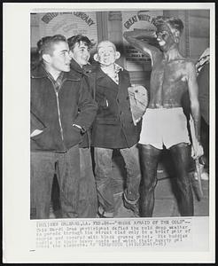 "Whose Afraid of the Cold"-- This Mardi Gras participant defied the cold damp weather to parade through the street clad only in a brief pair of shorts and covered with black grease paint. His buddies huddle in their heavy coats and watch their hearty pal brave the elements.