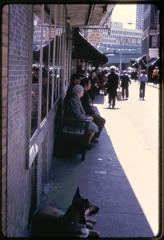 People sitting under an awning near Salem Wholesale Supply Co., Salem Street, North End