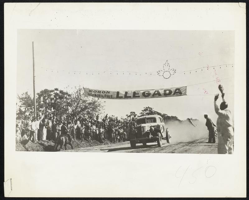 Eduardo Pedrazzini, pictured above in a Ford V-8 is getting the checkered flag at the finish line near Buenos Aires as winner of the 1000-mile Argentine road race, which he drove at the average speed of nearly a mile a minute. His elapsed time over a big circle was 16 hours and 51 minutes. Rules of the race permitted no rest periods for drivers, and Pedrazzini stopped only to refuel. He was followed across the finish line by other Ford V-8 cars in second, third, fourth and fifth places, and six additional Fords were among the 16 cars that finished in the money. Twenty-eight Fords were among the 44 cars that started.