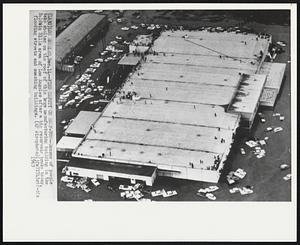 Find Safety on Roof-Top--Dozens of people take shelter on the roof of this large manufacturing building in the Baldwin Hills area of Los Angeles after a big reservoir broke today, flooding streets and smashing buildings.