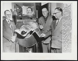 Graduates in Iron Lung-- Earl Rogers, 19, Valley Center, Kansas., kept up his high school studies and graduated this week from the Valley Center High School, despite his illness with polio and confinement in a iron lung. Earl smiles here as his diploma was presented by school board chairman, Byron T. Rowell. Earl's principal, L.E. Enterline (left) and Supt. John S. Sewars (center) helped bring commencement to the youth in his room at a hospital here. Earl's twin brother, Elmer, also graduated this week.