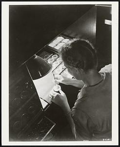 Reading segments of multifocal lenses are placed for fusing in the American Optical lens factory.