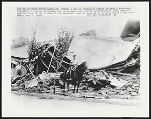 Nogales, Chile: A man on horseback stands outside a shattered building at Nogales following the earthquake that struck central Chile 3/28. Some 400 persons were feared killed in the disaster, most of them at La Calera, where a dam burst swept away 80 homes.