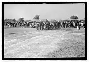 A crowd of people gathered by buses