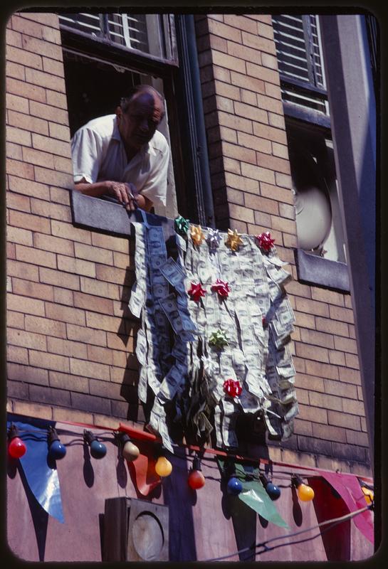 Man viewing religious procession from window, North End, Boston