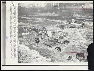 New Cars Swept Away in Flood--New automobiles parked on a dealer's lot before the rains started are wrecked in Four Mile run during a storm which dumped several inches of water on the Arlington and nearby Washington, D.C., area last night. State police reported 15 autos were swept into the stream.