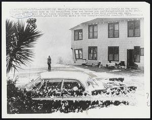 Man (background) watches helplessly as the stormy Atlantic Ocean chews away at his beachfront home and batches his car (foreground) in salty froth. The wall at the rear of the house collapsed a few minutes after this picture was made. Hurricane Dora, meanwhile, aimed her fierce winds at the Georgia-Carolina coast.