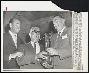 New York – Blind Golfer Gets Hogan Trophy – Clinton F. Russell, 61, former world blind golf champion, receives the Ben Hogan trophy today from Totten Heffelfinger, right, former U.S. Golf Association president, at annual dinner of the Metropolitan Golf Writers Association. Russell was honored for continuing the game despite a handicap. At left is Sam Snead who was among the 500 guests who turned out for the annual dinner at the Plaza Hotel.