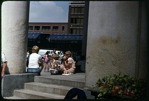 People eating on steps of Quincy Market