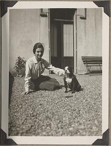 An unidentified woman sitting next to a Boston terrier