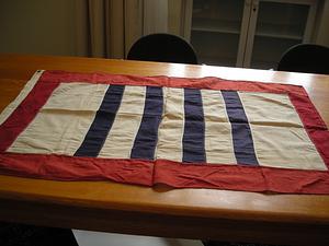 Banner with white ground centering four blue stripes