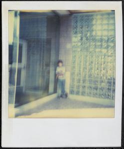 Young person in front of tile wall