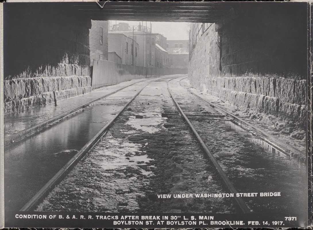 Distribution Department, Low Service Pipe Lines, condition of Boston & Albany Railroad tracks after break in 30-inch main, Boylston Street at Boylston Place (view under Washington Street Bridge), Brookline, Mass., Feb. 14, 1917