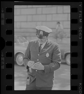 Policeman writes traffic ticket on Beacon Hill, Boston