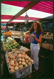 Saleswoman weighs produce in Haymarket Square, Boston